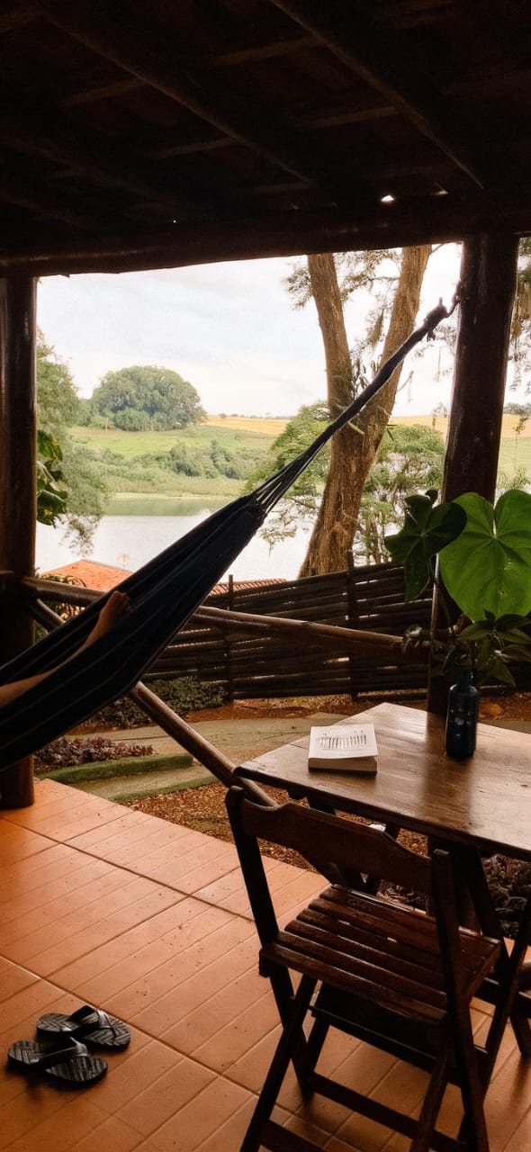 Varanda do chalé com rede e vista para a represa